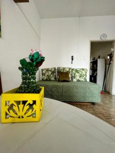 a living room with a couch and a vase of flowers at Studio no Largo da Carioca - Rio de Janeiro in Rio de Janeiro