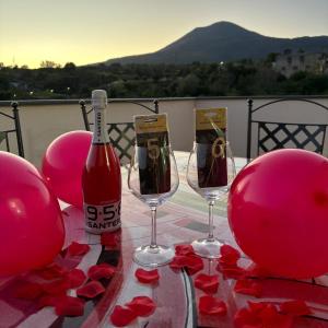einen Tisch mit zwei Weingläsern und roten Ballons in der Unterkunft Villa Manzo relais -Pompei Vesuvius in Boscotrecase