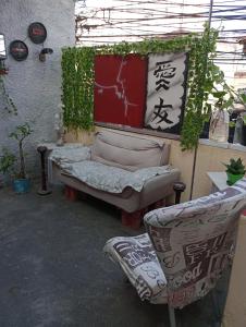 a room with a couch and two chairs in it at Pousada Lua Nua in Niterói