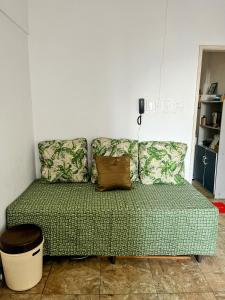 - un canapé vert dans une chambre avec téléphone dans l'établissement Studio no Largo da Carioca - Rio de Janeiro, à Rio de Janeiro