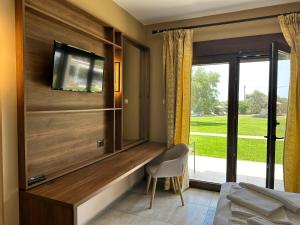 a living room with a tv on a wall at Saint George Sithonia in Neos Marmaras