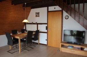 a dining room with a table and chairs and a television at Ferienhaus Maria in Nagel
