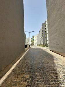 une rue vide dans une ville avec de grands bâtiments dans l'établissement Appartement reaprom, à Mostaganem