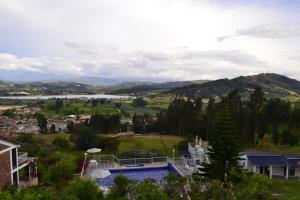 vista su una casa con piscina e lago di Miravalle Suites a Paipa