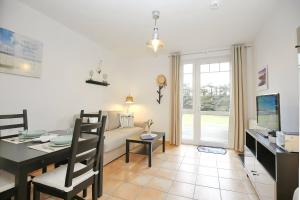 a living room with a couch and a table at Ostseeliebe - Sünnenkieker WE7, Beckerwitz in Beckerwitz