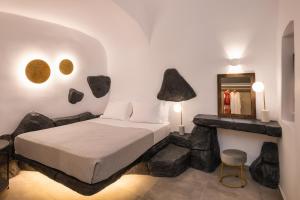 a bedroom with a bed with rocks on the wall at Elia 2 bedroom cavehouse with indoor jacuzzi in Vóthon