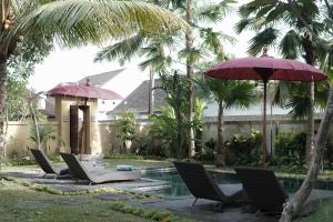 a group of chairs and umbrellas next to a pool at Sentana Villa Ubud in Ubud