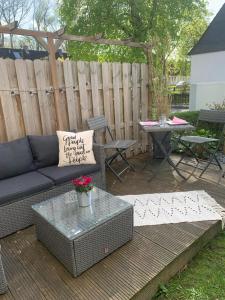 a patio with a couch and a table and a fence at Nordlicht in Wilhelmshaven