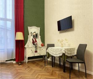 una sala da pranzo con tavolo e TV di Austrian Lviv Apartments a Lviv