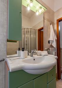 uma casa de banho com um lavatório branco e um espelho. em Casa Kira em Livorno