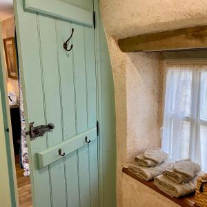 a door in a room with towels on a shelf at Une nuit chez une artisane in Josselin