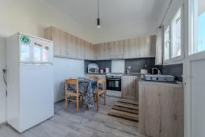 a kitchen with wooden cabinets and a table and a refrigerator at Anastasia's lemon garden in Artemida +36 photos