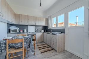 a kitchen with wooden cabinets and a table and a window at Anastasia's lemon garden in Artemida