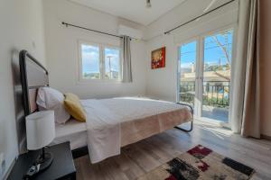 a bedroom with a bed and a large window at Anastasia's lemon garden in Artemida