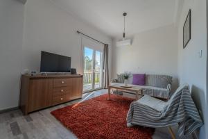 a living room with a tv and a couch at Anastasia's lemon garden in Artemida