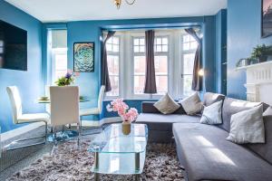 un soggiorno blu con divano e tavolo di Dubai Media City Convenient Apartments a Dubai