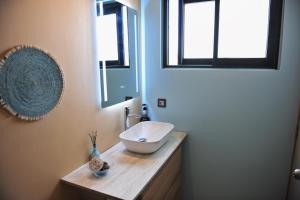 un bagno con lavandino a ciotola su un bancone in legno di Golf View Villa a Roches Noires