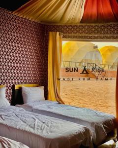 two beds in a room with a view of the beach at Sunrise Wadi Rum Camp in Wadi Rum