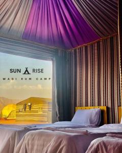 Sunrise Wadi Rum Camp في وادي رم: غرفة نوم مع سرير بسقف أرجواني
