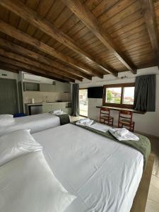 two large white beds in a room with a kitchen at Azzurro in Paleros