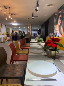 una mesa larga con platos blancos en un restaurante en MiLLER's Inn Panzió és Étterem, en Nagyoroszi