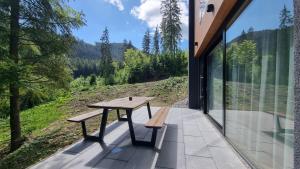 a picnic table and bench on a patio with a view at Chalets Hrabovo in Ružomberok +97 photos