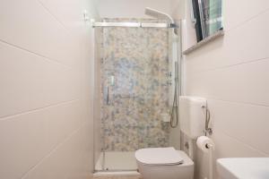 a bathroom with a shower with a toilet and a sink at Apartments Villa Rosa in Rovinj