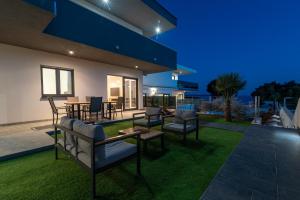 a patio with chairs and tables on a lawn at Villa Helena in Trogir