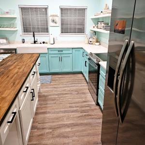 a kitchen with blue cabinets and a refrigerator at Pat's Perch in Rockport +31 photos