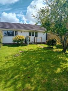 a house with a yard with green grass at The Bungalow Lymington 1 mile from New Forest in Lymington