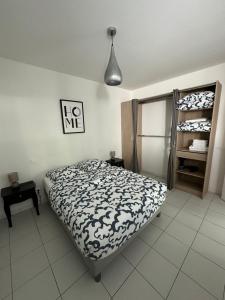 una camera da letto con un letto con un piumone bianco e nero di Appartement de charme n7 a Grimaud