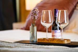 due bicchieri da vino e un vaso di fiori su un tavolo di ACCADEMIA VINE LODGE a Capriva del Friuli