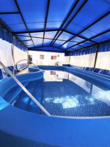 una piscina en un edificio con techo azul en Hotel Cervantes en Termas de Río Hondo
