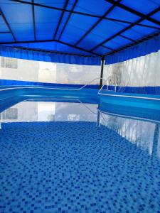 basen z niebieskim sufitem i wodą w obiekcie Hotel Cervantes w mieście Termas de Río Hondo