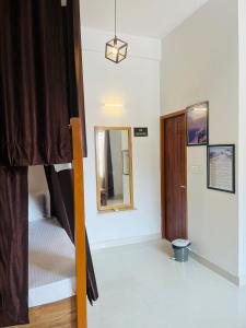 Zimmer mit einem Bett und einem Spiegel in der Unterkunft Rootz in Dehradun