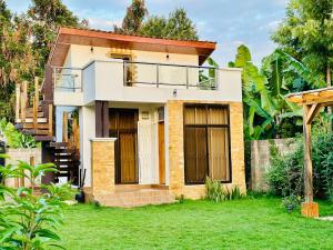 ein Haus mit Balkon im Hof in der Unterkunft Golden hour tiny house in Arusha