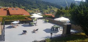 シュチルクにあるEDEN Szczyrkの山の上にあるテーブルと椅子とパラソルのあるパティオ