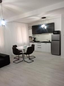 een woonkamer met een tafel en stoelen en een keuken bij Apartament Central in Tulcea
