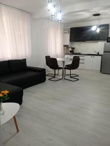 een woonkamer met een zwarte bank en een tafel bij Apartament Central in Tulcea