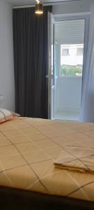 a bed in a room with a window and a door at Apartament Pro Confort in Tulcea