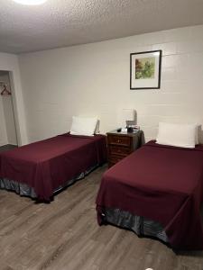 een hotelkamer met 2 bedden en een dressoir bij Tip Top Motel in Lihue