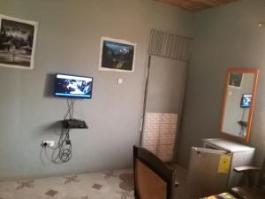 sala de estar con TV en la pared en Akomapa Village, en Elmina