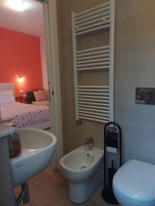 a bathroom with a sink and a toilet and a bed at Albamare in Monterosso al Mare