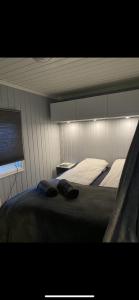 a bedroom with a bed with two pillows on it at Jacuzzi, utekjøkken og sjøutsikt i hel hytte ved sjøen in Hitra