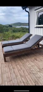 a bed sitting on top of a wooden deck at Jacuzzi, utekjøkken og sjøutsikt i hel hytte ved sjøen in Hitra