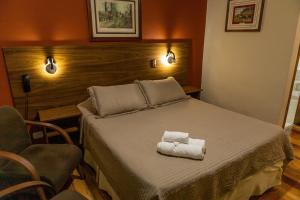 カンポス・ド・ジョルドンにあるPousada Kaliman Premiumのベッドルーム1室(ベッド1台、タオル2枚付)
