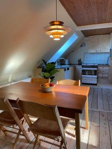 a dining room table with a bowl of fruit on it at Homestay in charming house on the countryside in Rønne +44 photos