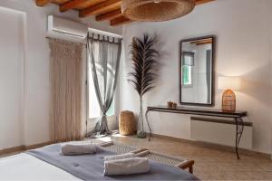 een slaapkamer met een bed en een spiegel bij BATIS Beach House in Kypri