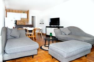 uma sala de estar com 2 sofás e uma sala de jantar em La Sirène, à 250 m de la plage, T2 lumineux avec une terrasse spacieuse de15m² em Saint-Cyprien