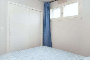 ein Schlafzimmer mit einem Bett und einem Fenster in der Unterkunft La Sirène, à 250 m de la plage, T2 lumineux avec une terrasse spacieuse de15m² in Saint-Cyprien